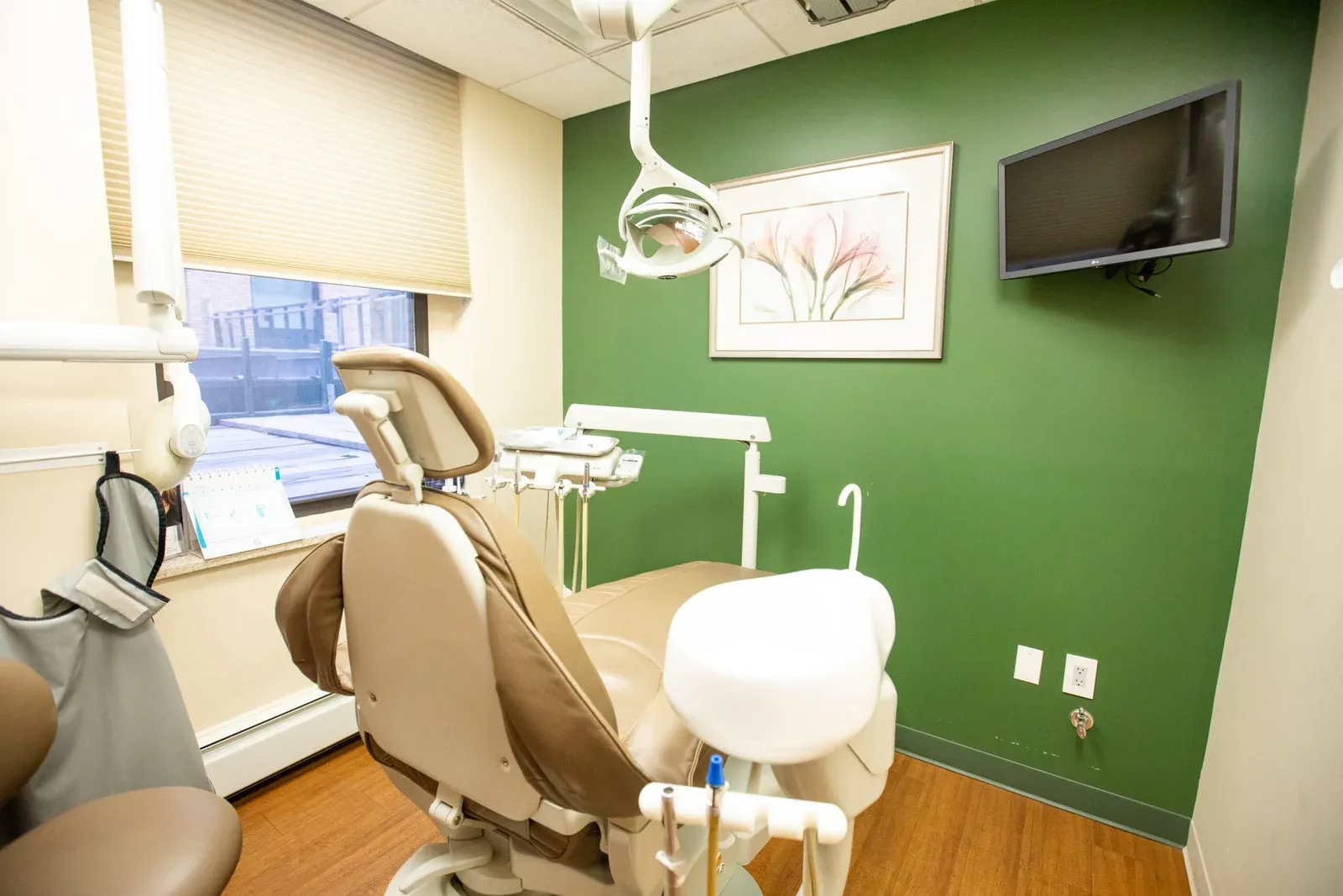 Dental operatory with green accent wall and patient chair at Creative Dentistry of Brooklyn Heights