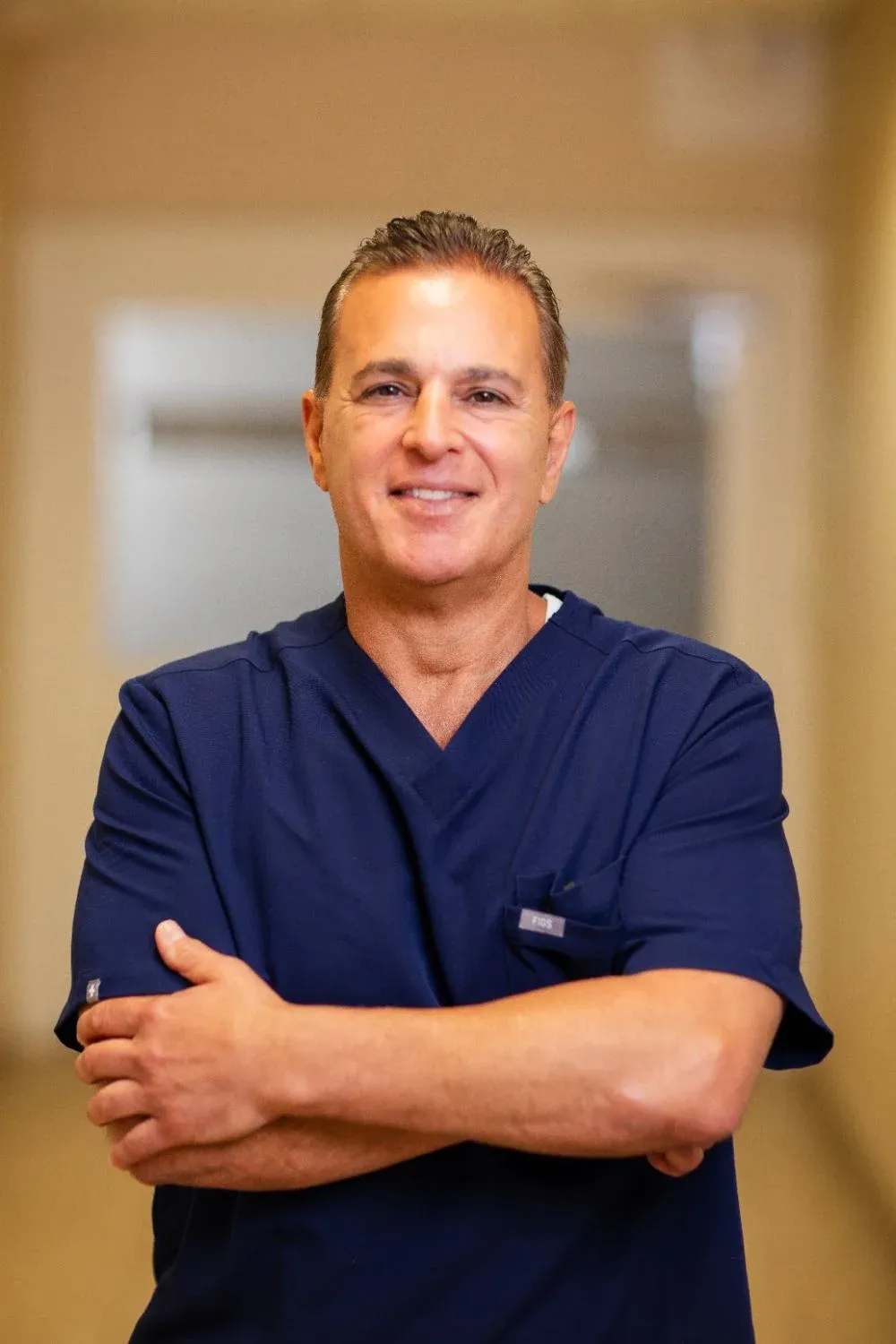Dr. Matthew Bellafiore, DDS, dentist at Creative Dentistry of Brooklyn Heights, standing with arms crossed in the office hallway
